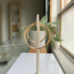 Pair of large gold hoop earrings mounted on a white display stand in a jewelry shop setting