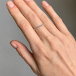 Elegant silver bead ring worn on the ring finger of a left hand, close-up shot.