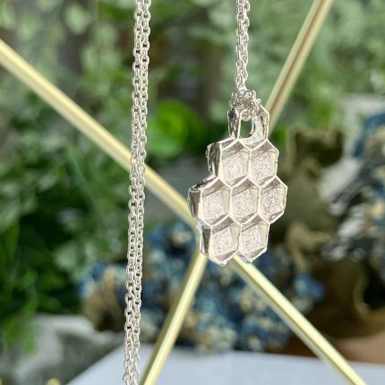 Silver honeycomb pendant on a delicate chain, with hexagonal panels forming a clustered shape.