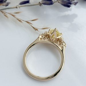 Gold ring with an ornate lattice/gallery setting and a yellow gemstone centerpiece