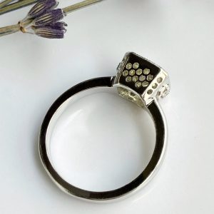 Silver ring with a square pavé-setting cluster of small stones at the top, on a white background.