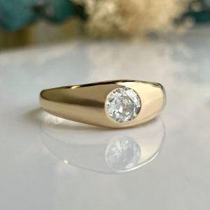 Gold signet-style ring with a bezel-set round diamond