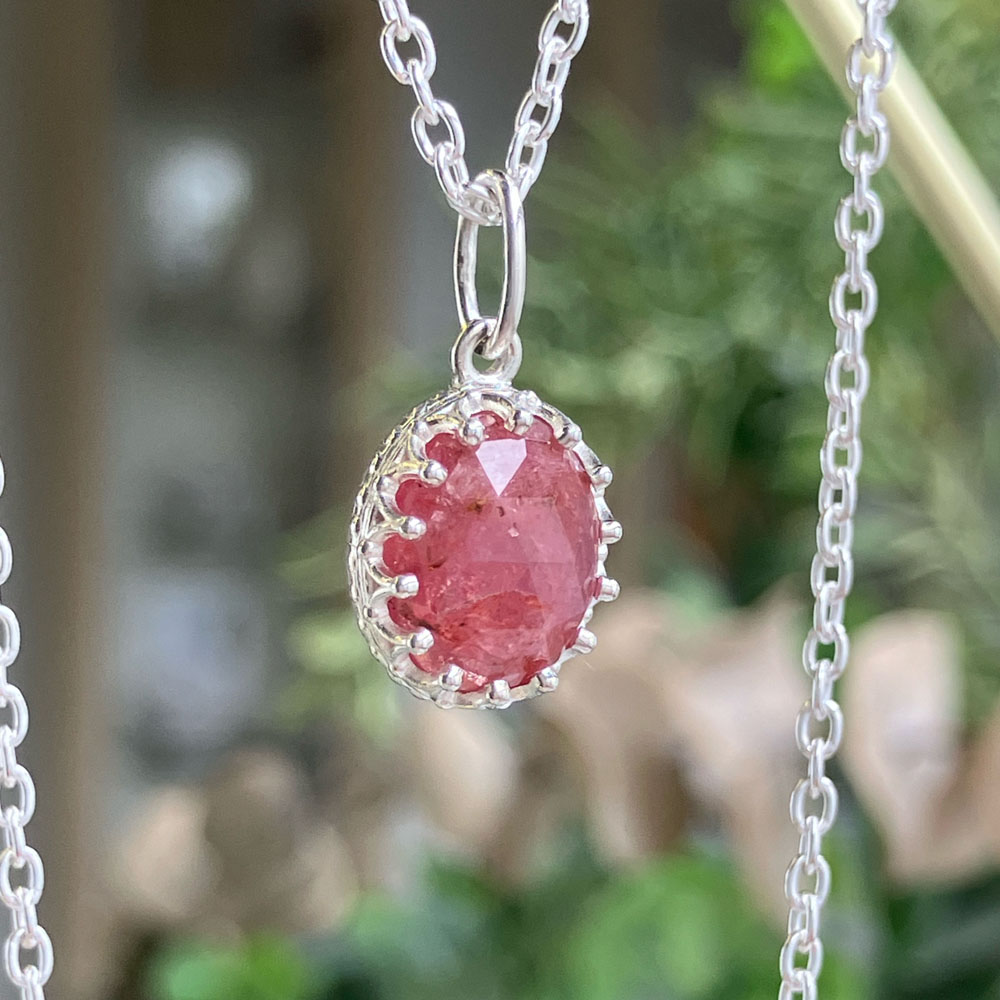 rose cut pin sapphire silver pendantjpeg | Posy Fine Jewellery Toronto Oval pink faceted gemstone pendant in a detailed silver bezel on a thin chain, close-up.