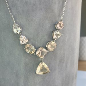 Silver necklace with alternating clear and pale champagne crystals in a stepped V-shaped pendant.